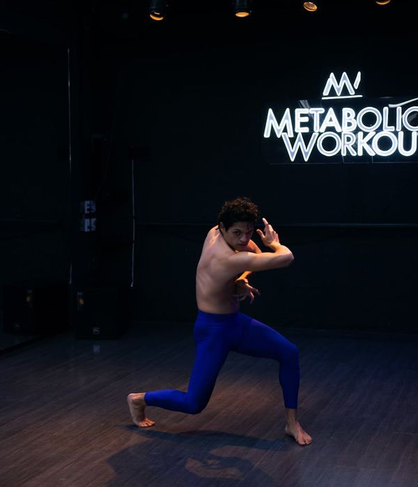 Man performing a controlled strength exercise in a modern, dark environment.