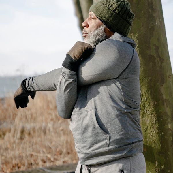 Silhouette of a man stretching against a backdrop suggesting vitality and energy flow.